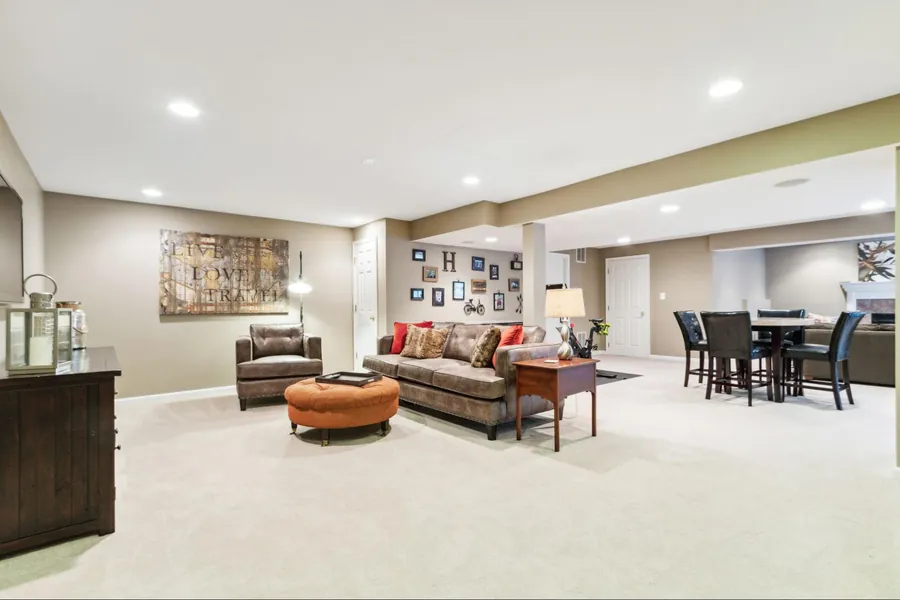 Sold home — finished lower level with seating, gallery wall, and game table