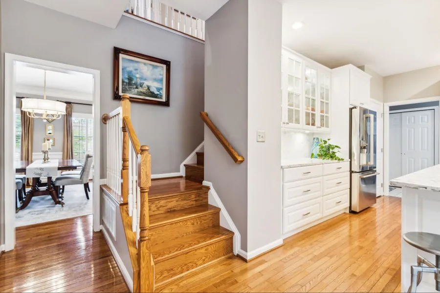 Sold home — foyer with hardwood staircase open to dining and kitchen