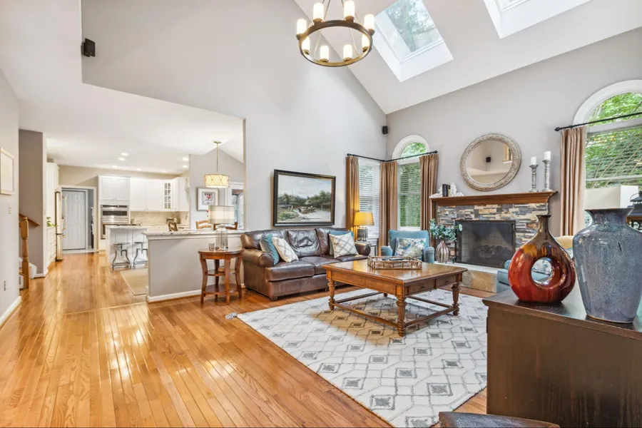 Sold home — great room with cathedral ceiling, skylights, and stone fireplace
