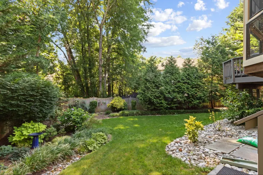 Sold home — landscaped backyard with mature trees and stone garden borders